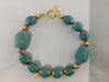BT21: Turquoise and bronze bracelet with 2 carved Buddhas and gold metal toggle