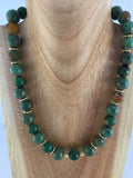 Babs II:  has green ceramic and faceted green/rust Agate with gold metal inserts and toggle