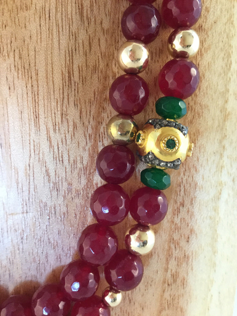 RUBY: solid Gold & emerald bead, surrounded by Emeralds.